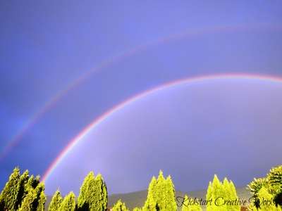 A double rainbow above a tree line in Armstrong, BC.